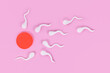 Abstract sperm cells swimming towards egg cell on pink background