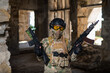 © Михаил Решетников - A woman in an army uniform holds a firearm in an abandoned building.