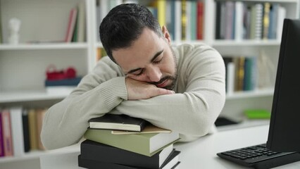 Sticker - Young hispanic man student sleeping with head on books at library university