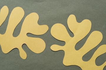 Sticker - two cut yellow paper shapes (polyp, columnar, organic, or finger) on rough green paper