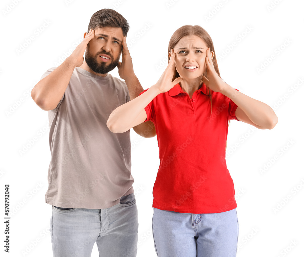 Young couple suffering from loud noise on white background