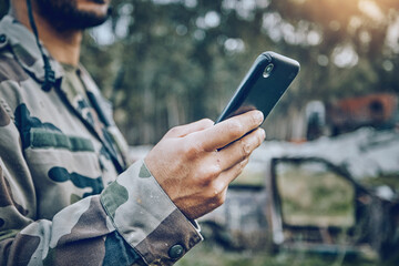 Wall Mural - Military soldier, mobile phone and communication while outdoor for connection, safety and security. Army person with a smartphone for social media, contact or chat on a field, boot camp or at war