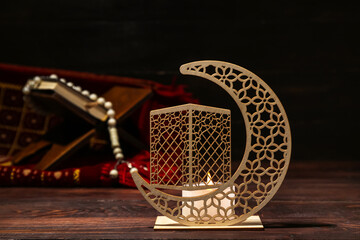 Wall Mural - Decorative crescent with burning candle for Ramadan on dark wooden table, closeup