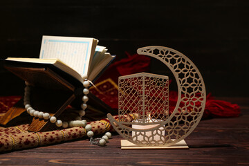 Wall Mural - Decorative crescent with burning candle, Koran and tasbih for Ramadan on wooden table