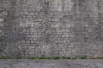 Stone facade grey street wall assembled with gray pebbles of different sizes background