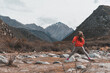 © Cavan Images - Girl jumping rocks in mountainous area