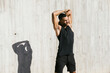 © Cavan Images - African American male athlete stretching against concrete wall