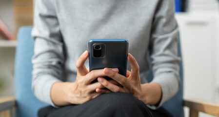 Wall Mural - Hand holding smartphone with using social media on internet on table.