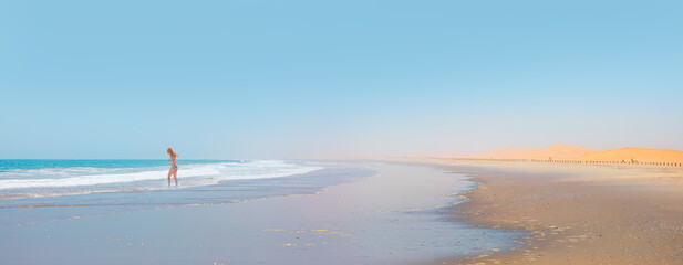 Wall Mural - Girl on tropical beach - Beautiful woman in bikini enjoy a swim in the sea - Namib desert with Atlantic ocean meets near Skeleton coast - 
Namibia, South Africa