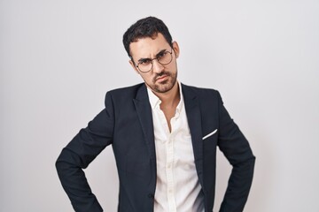 Wall Mural - Handsome business hispanic man standing over white background skeptic and nervous, frowning upset because of problem. negative person.