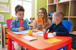 © Krakenimages.com - Teacher with boys sitting on table having language lesson at kindergarten