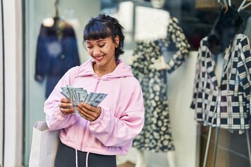 Wall Mural - Young woman smiling confident counting dollars at street