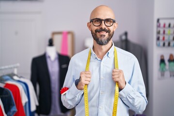 Poster - Young bald man tailor smiling confident standing at tailor shop