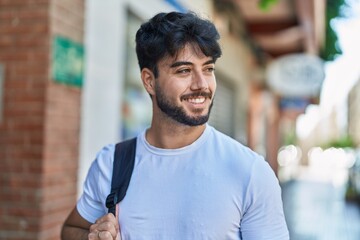 Sticker - Young hispanic man smiling confident wearing backpack at street