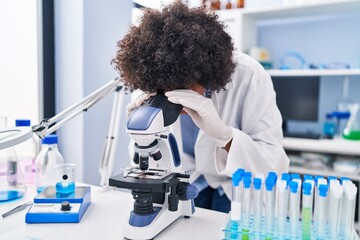 Poster - African american woman scientist using microscope at laboratory