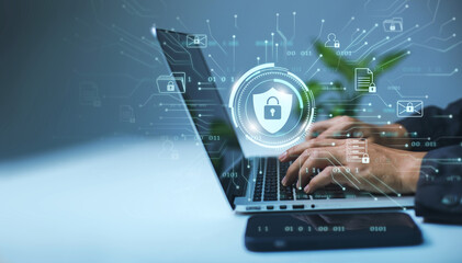 Fototapete - A businessman works on his laptop at home with a virtual display showing a symbol to signify cyber security privacy and online data protection