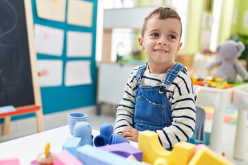 Sticker - Adorable caucasian boy playing with construction blocks at kindergarten