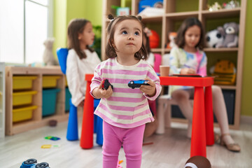 Poster - Group of kids preschool students drawing on paper holding cars toy at kindergarten