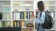 © Krakenimages.com - Young beautiful hispanic woman student using smartphone standing at library university