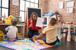 © Krakenimages.com - Teacher with boy and girl sitting on floor having maths lesson at kindergarten