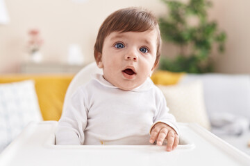 Sticker - Adorable hispanic toddler sitting on highchair at home