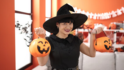 Sticker - Young chinese woman wearing witch costume holding halloween pumpkin baskets at home