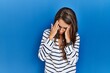 © Krakenimages.com - Young hispanic woman standing over blue isolated background with sad expression covering face with hands while crying. depression concept.