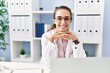 © Krakenimages.com - Young hispanic woman wearing doctor uniform working at clinic