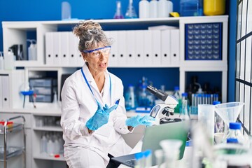 Canvas Print - Middle age woman scientist having video call at laboratory