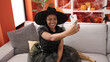 © Krakenimages.com - African american woman wearing witch costume make selfie by smartphone at home