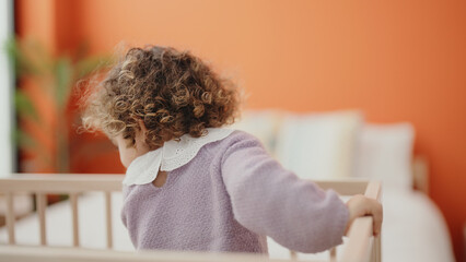 Sticker - Adorable hispanic girl standing on cradle at bedroom