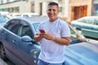 © Krakenimages.com - Young latin man using smartphone leaning on car at street