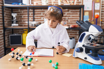 Sticker - Adorable caucasian boy student holding molecules at classroom