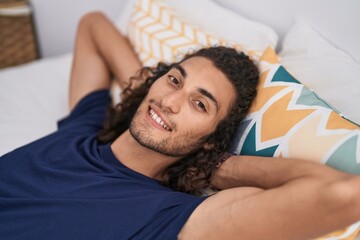 Canvas Print - Young hispanic man smiling confident lying on bed at bedroom