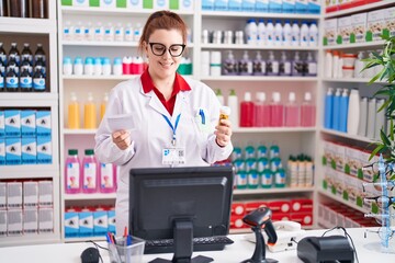 Poster - Young beautiful plus size woman pharmacist holding pills bottle reading prescription at pharmacy