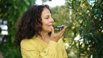 Poster - Middle age hispanic woman smiling confident talking on the smartphone at park