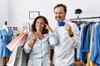 © Krakenimages.com - Hispanic middle age couple holding shopping bags and credit card smiling pointing to head with one finger, great idea or thought, good memory