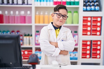 Sticker - Young hispanic kid working at pharmacy drugstore happy face smiling with crossed arms looking at the camera. positive person.