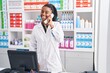 © Krakenimages.com - African american woman pharmacist talking on telephone using computer at pharmacy