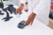© Krakenimages.com - Middle age african american woman pharmacist using credit card and data phone at pharmacy