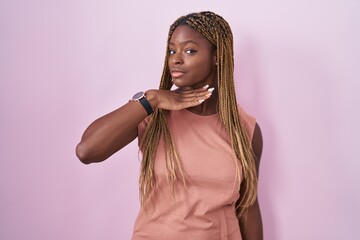 Sticker - African american woman with braided hair standing over pink background cutting throat with hand as knife, threaten aggression with furious violence