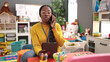 © Krakenimages.com - African woman working as teacher with tablet speaking on the phone at kindergarten
