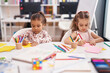 © Krakenimages.com - Two kids preschool students sitting on table drawing on paper at classroom