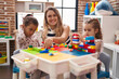 © Krakenimages.com - Teacher with girls playing with construction blocks sitting on table at kindergarten