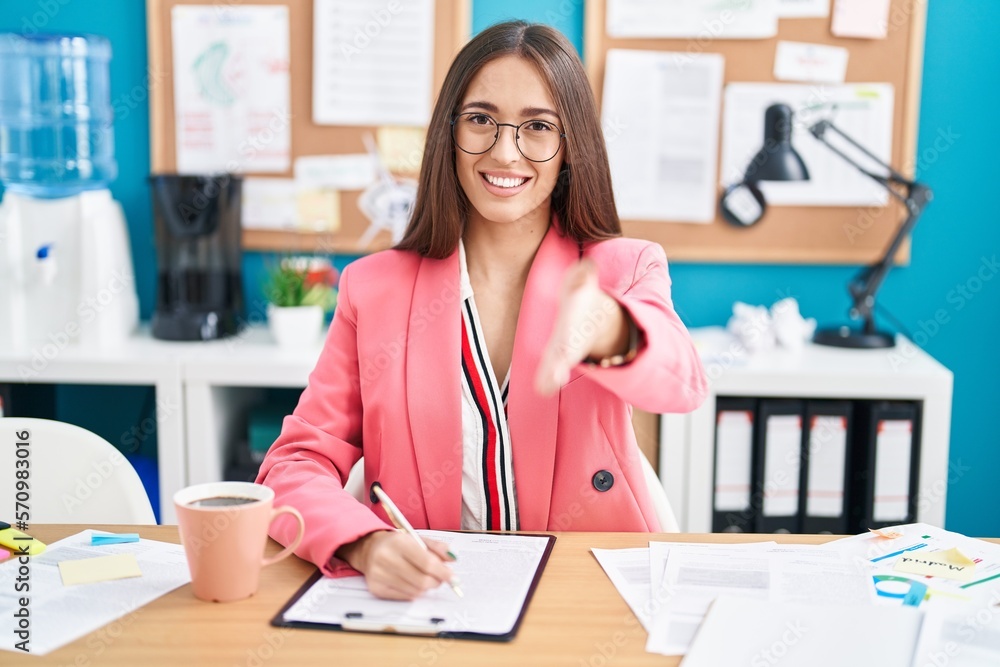 Young hispanic woman working at the office wearing glasses smiling ...