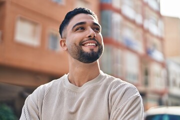 Wall Mural - Young arab man smiling confident standing at street