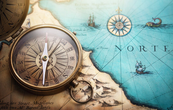 Wall Mural - Magnetic old compass on world map.Travel, geography, navigation, tourism and exploration concept background. Treasure Island on the Pirate Map.