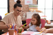 © Krakenimages.com - Teacher and toddler smiling confident cutting paper at kindergarten