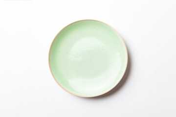 Sticker - Top view of isolated of colored background empty round green plate for food. Empty dish with space for your design