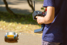 Teen Boy With Electric Remote Control Car Toy Play Outdoor On Sidewalk